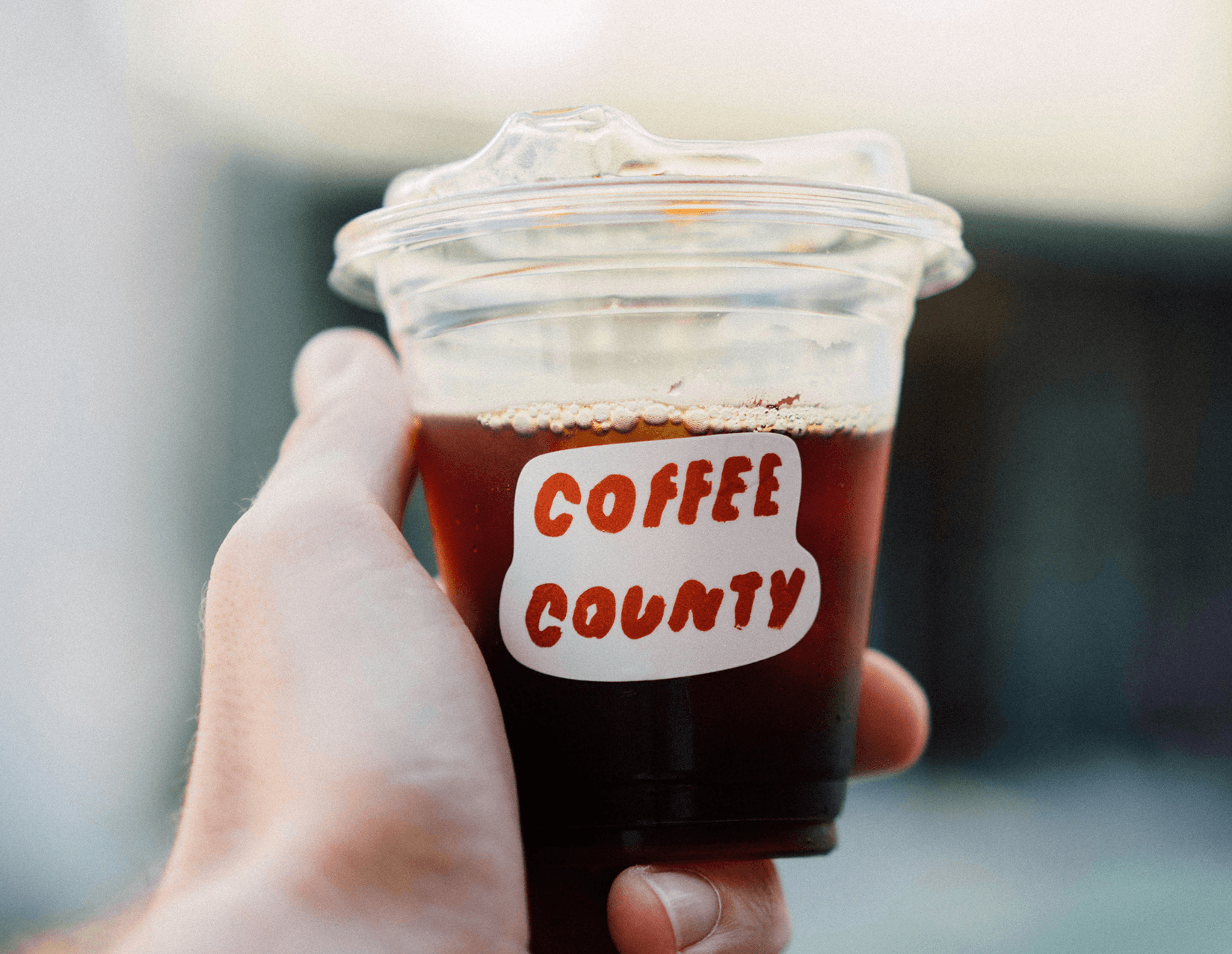 Hand holding iced coffee cup